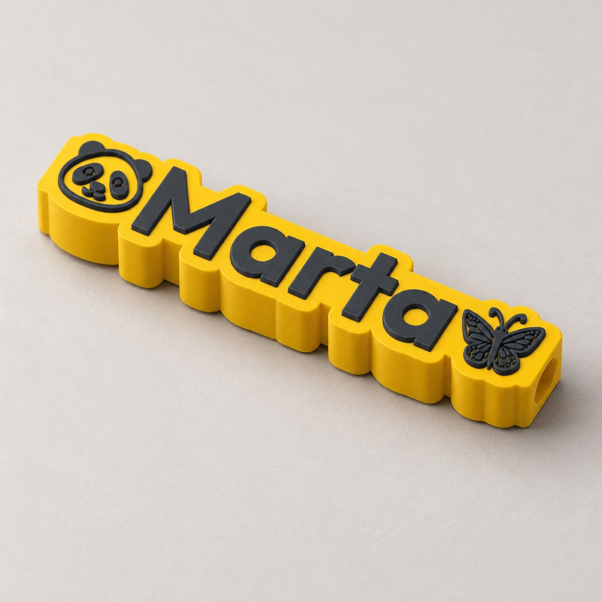 Emoji Name Pencil Topper: yellow 'Marta' topper alone at a three-quarter angle