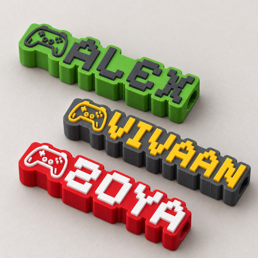 Gamer Name Pencil Topper: three toppers (ALEX green, VIVAAN grey with yellow, ZOYA red with white) laid flat in a loose fan, top-down at a slight angle
