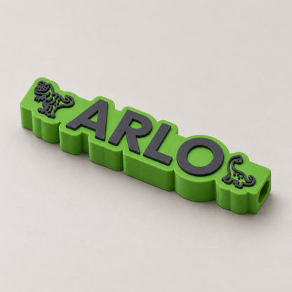 Dinosaur Name Pencil Topper: green 'ARLO' dinosaur topper alone at a three-quarter angle