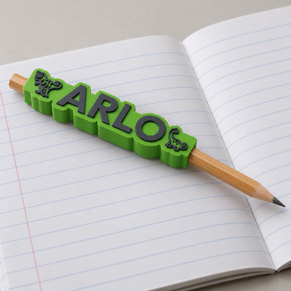 Dinosaur Name Pencil Topper: 'ARLO' topper on a pencil lying on an open school exercise book
