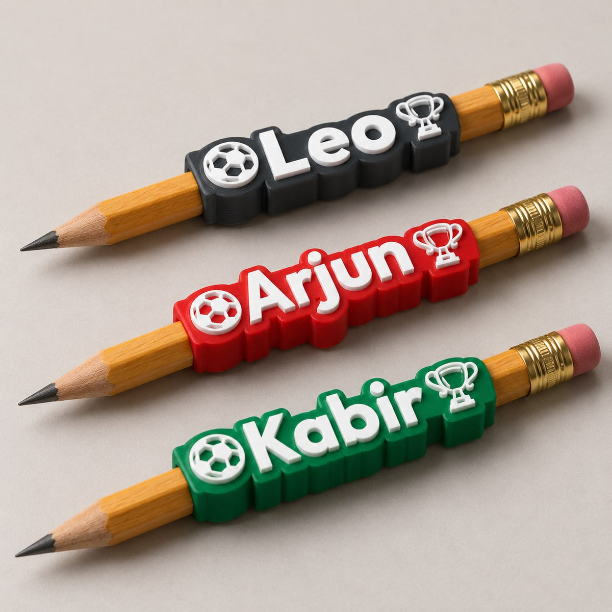 Football Name Pencil Topper: three toppers (Leo, Arjun, Kabir) each on the top of a pencil, the pencils lying side by side