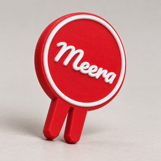 Glass Name Marker: red 'Meera' marker alone, standing upright at a three-quarter angle
