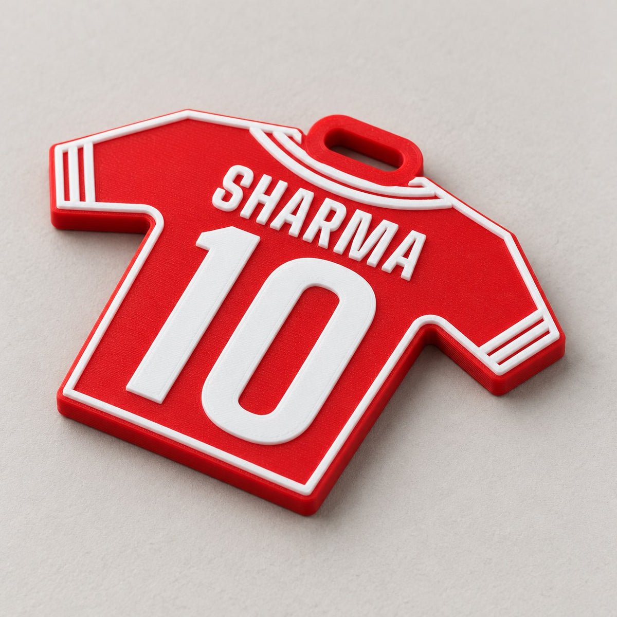 Jersey Kit Bag Tag: red 'SHARMA 10' tag alone at a three-quarter angle