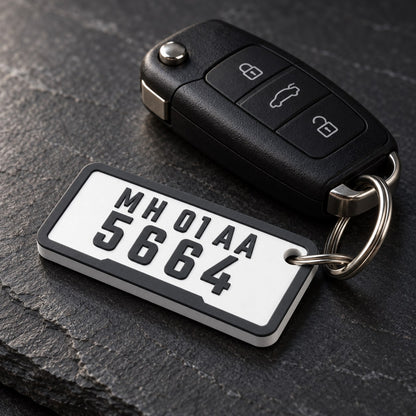 Number Plate Keychain: 'MH 01 AA 5664' keychain on a steel split ring next to a black car key fob on a dark slate surface