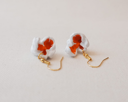 Pair of earrings with a white base and red floral design on a light background, branded 'Eyf_design'.