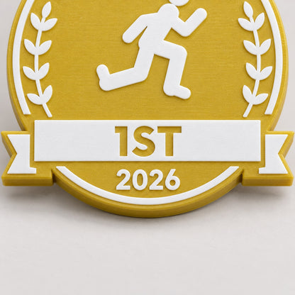 Close-up of the 1ST banner, runner and print texture on a gold-yellow Sports Day medal