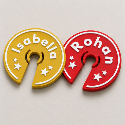 Wine Glass Name Tag: two rings, the gold Isabella and a red Rohan, lying flat overlapping slightly, top-down