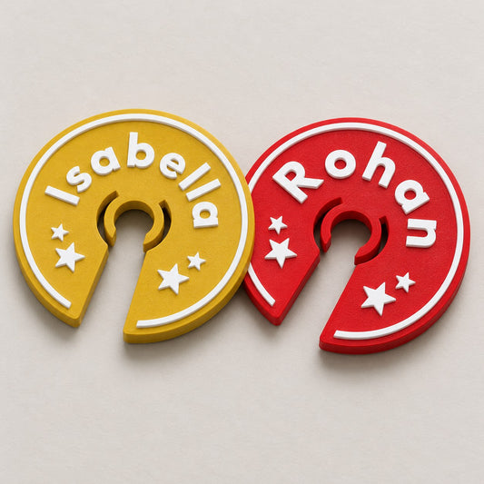 Wine Glass Name Tag: two rings, the gold Isabella and a red Rohan, lying flat overlapping slightly, top-down